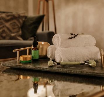 Towels and spa supplies on a table in a dim lit room.