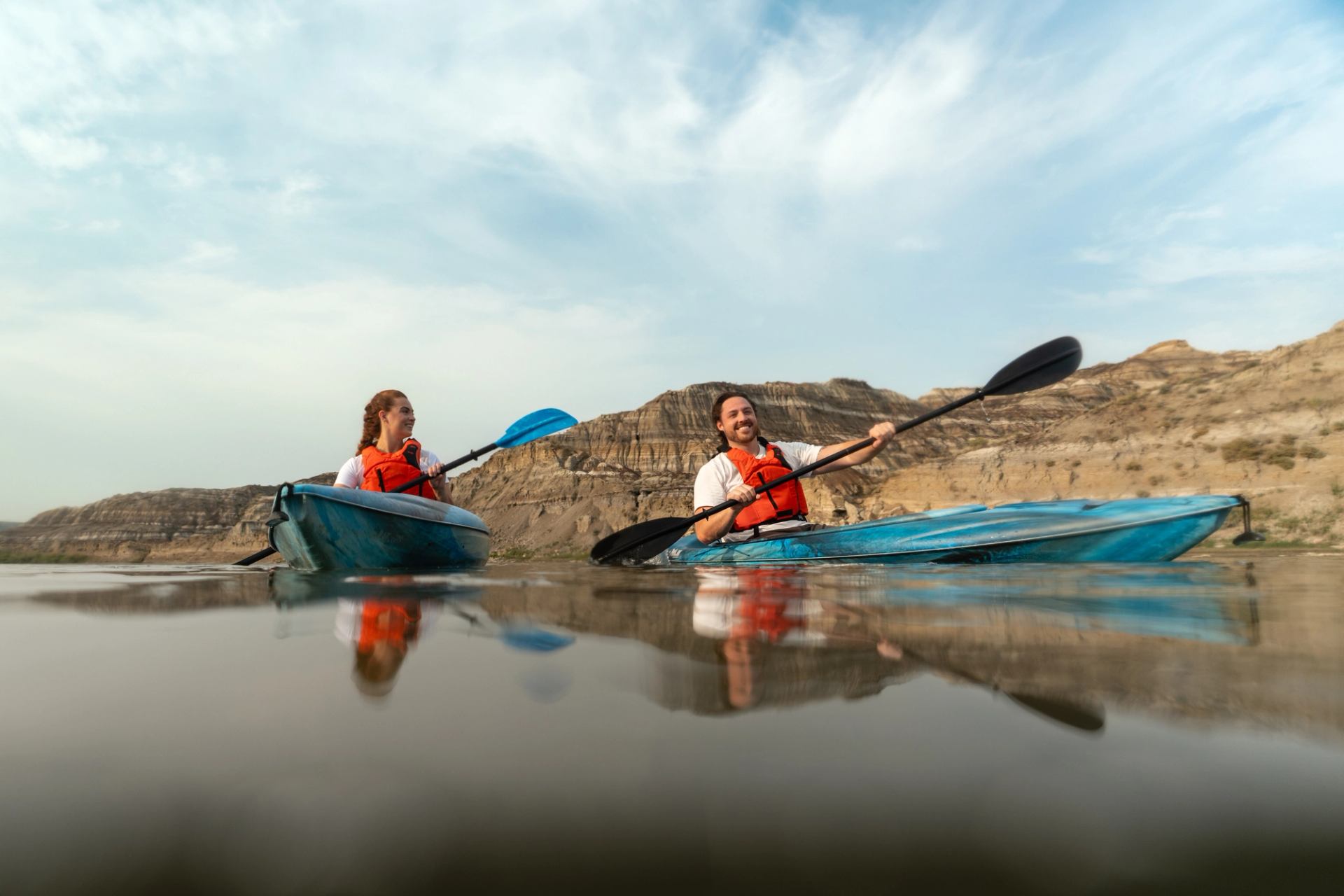 A couple Kayaking with the badlands in the background.