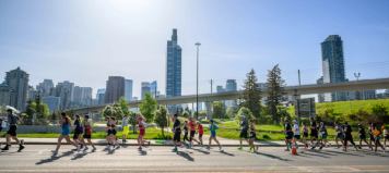 Dozens of runners pass Calgary’s skyline and downtown greenspace during the Calgary Marathon weekend.