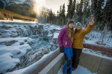 A couple of girls take a selfie at Athabasca Falls in Jasper National Park