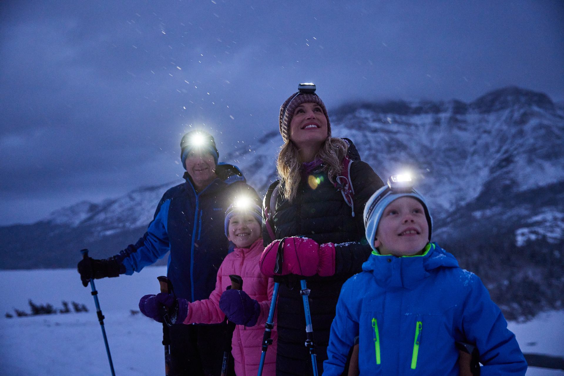 A family enjoys a guided nighttime snowshoe and stargazing tour with Dark Sky Guides