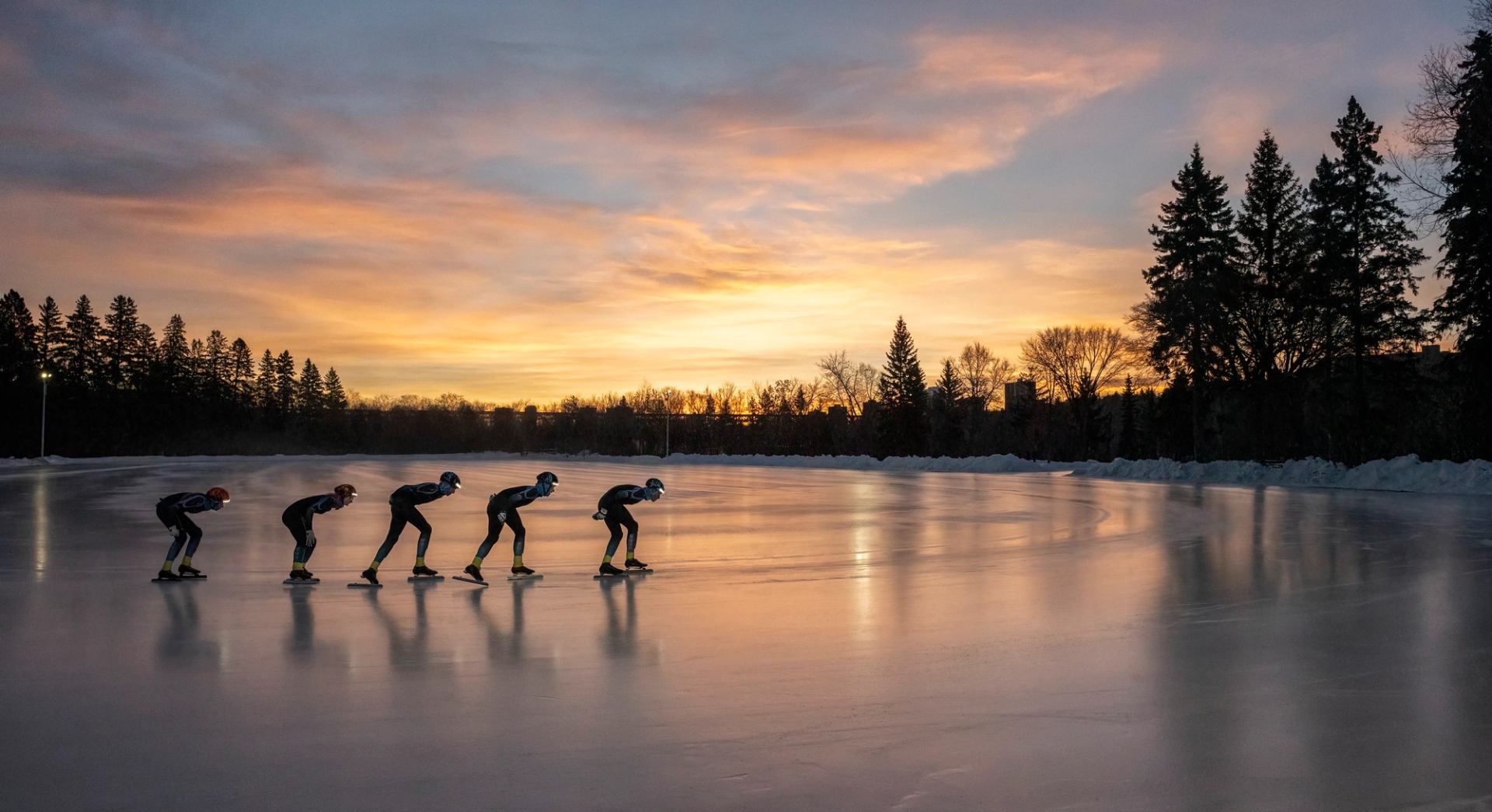 A line of speed skaters circle the outdoor rink at sunset in Edmonton.