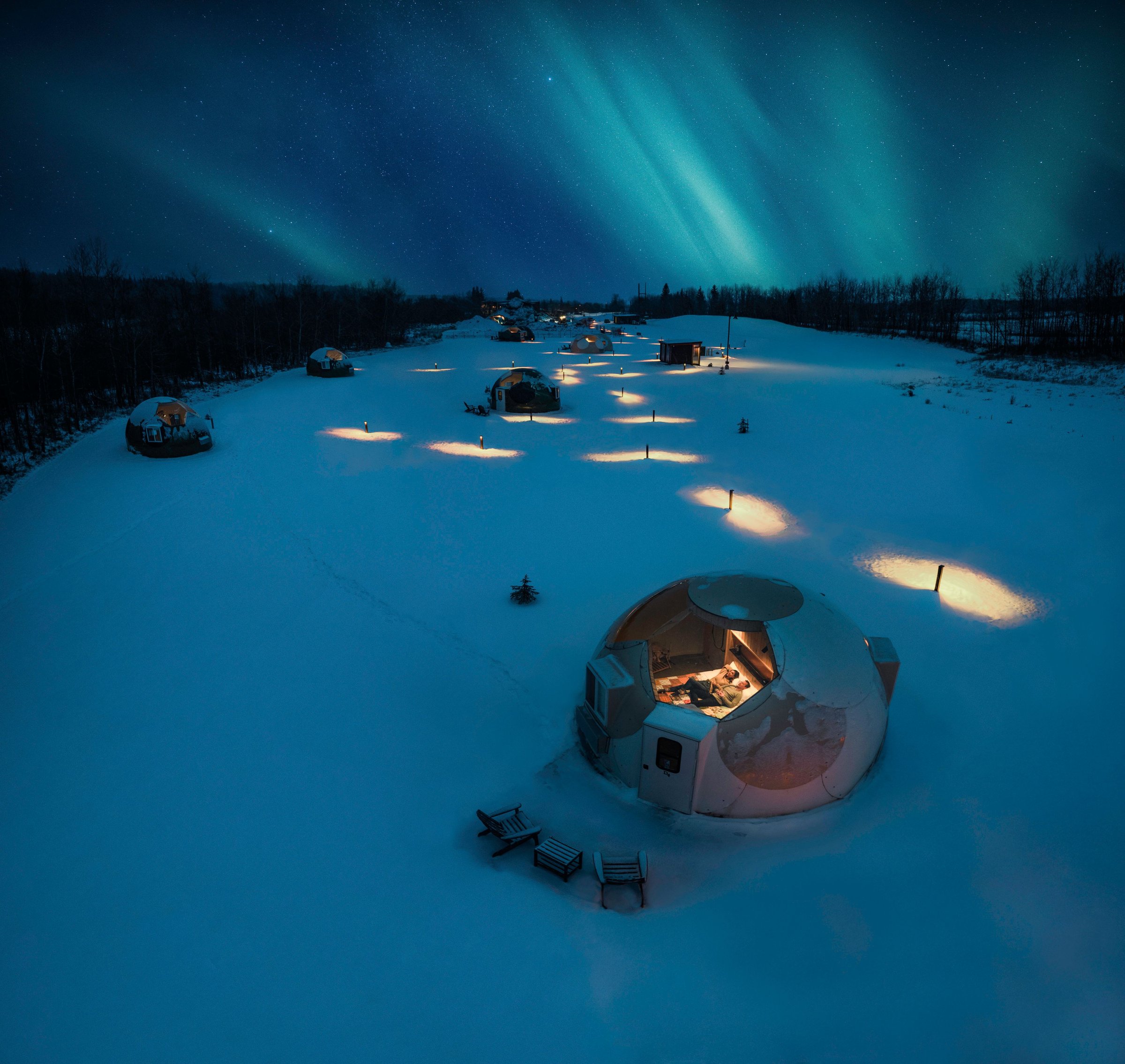 Night sky watching domes with the auroras above in the night sky.