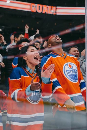 Edmonton Oilers hockey fans cheering on their hockey team from the arena stands.