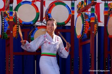 Young female performer playing drums at a Chinatown Street Festival