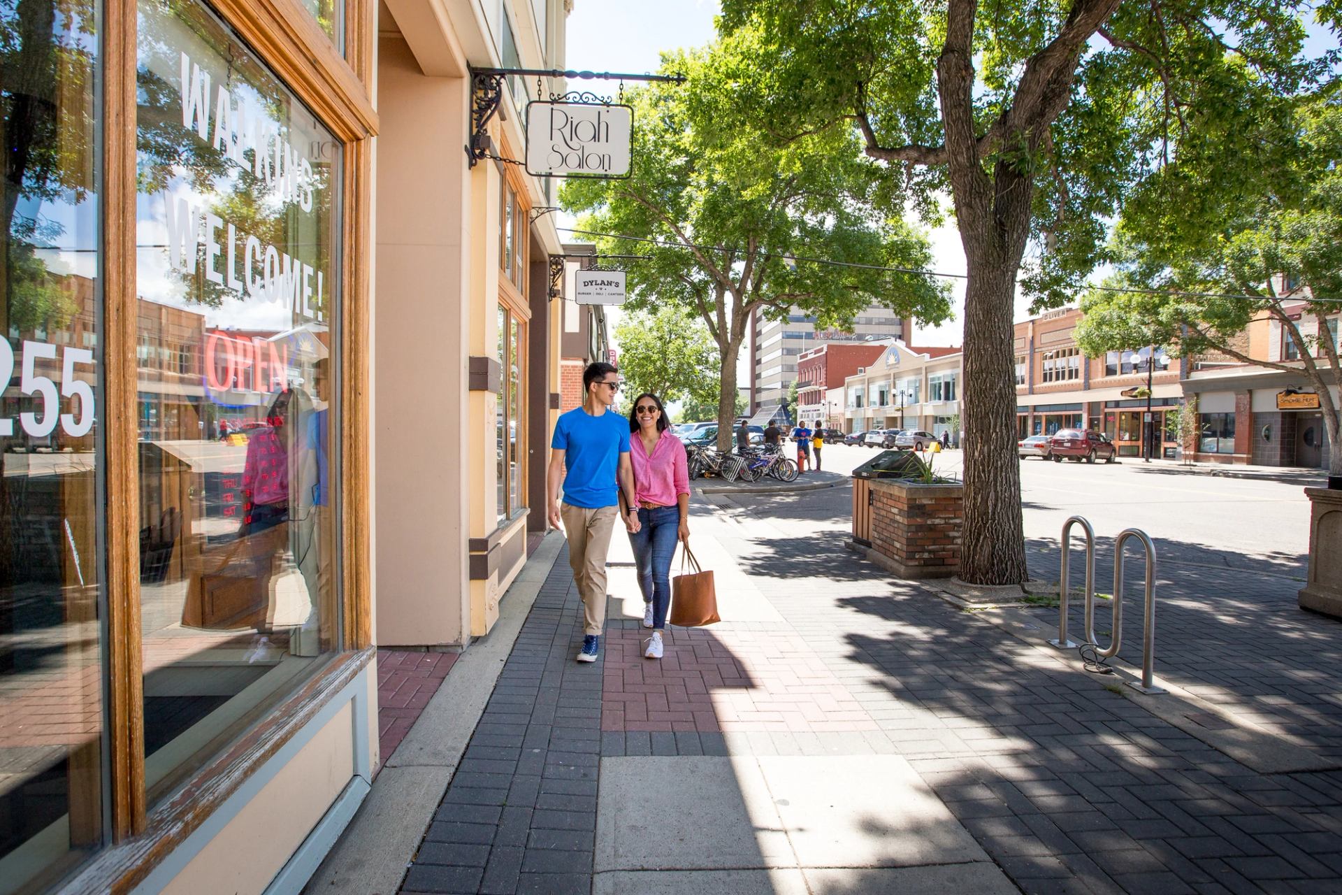 A couple walks down a shop-lined street in Lethbridge.