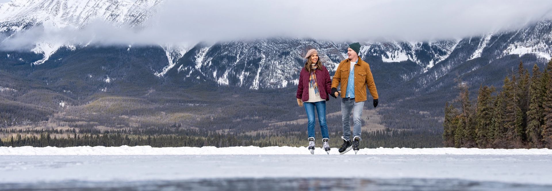 A couple skating on a lake in Jasper.