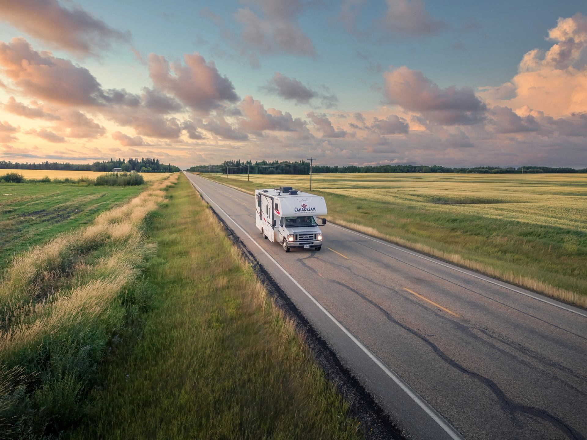 An RV travels along a prairie road in Alberta.