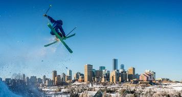 Person ski jumping with downtown Edmonton in background