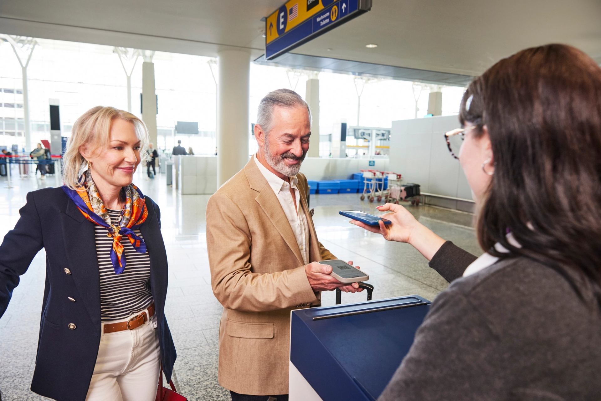 A pair of travellers has their boarding passes scanned at YYC Calgary Interational Airport.