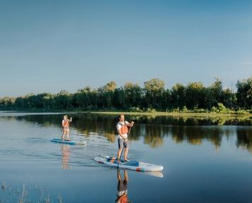 Two people on stand up paddle boards on Syne River near Fort McMurray.