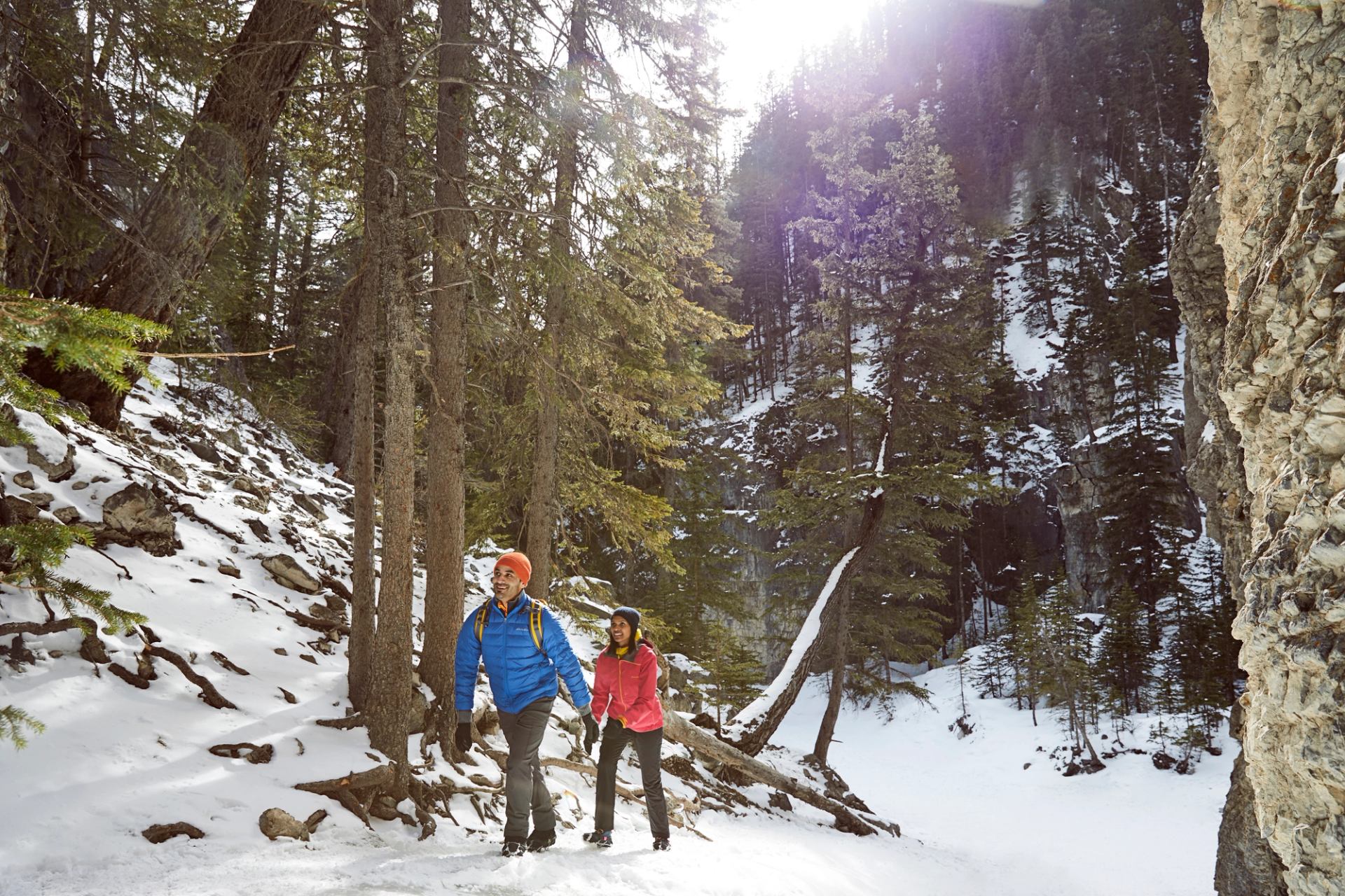 A couple winter hiking through Grotto Canyon near Canmore in Kananaskis Country