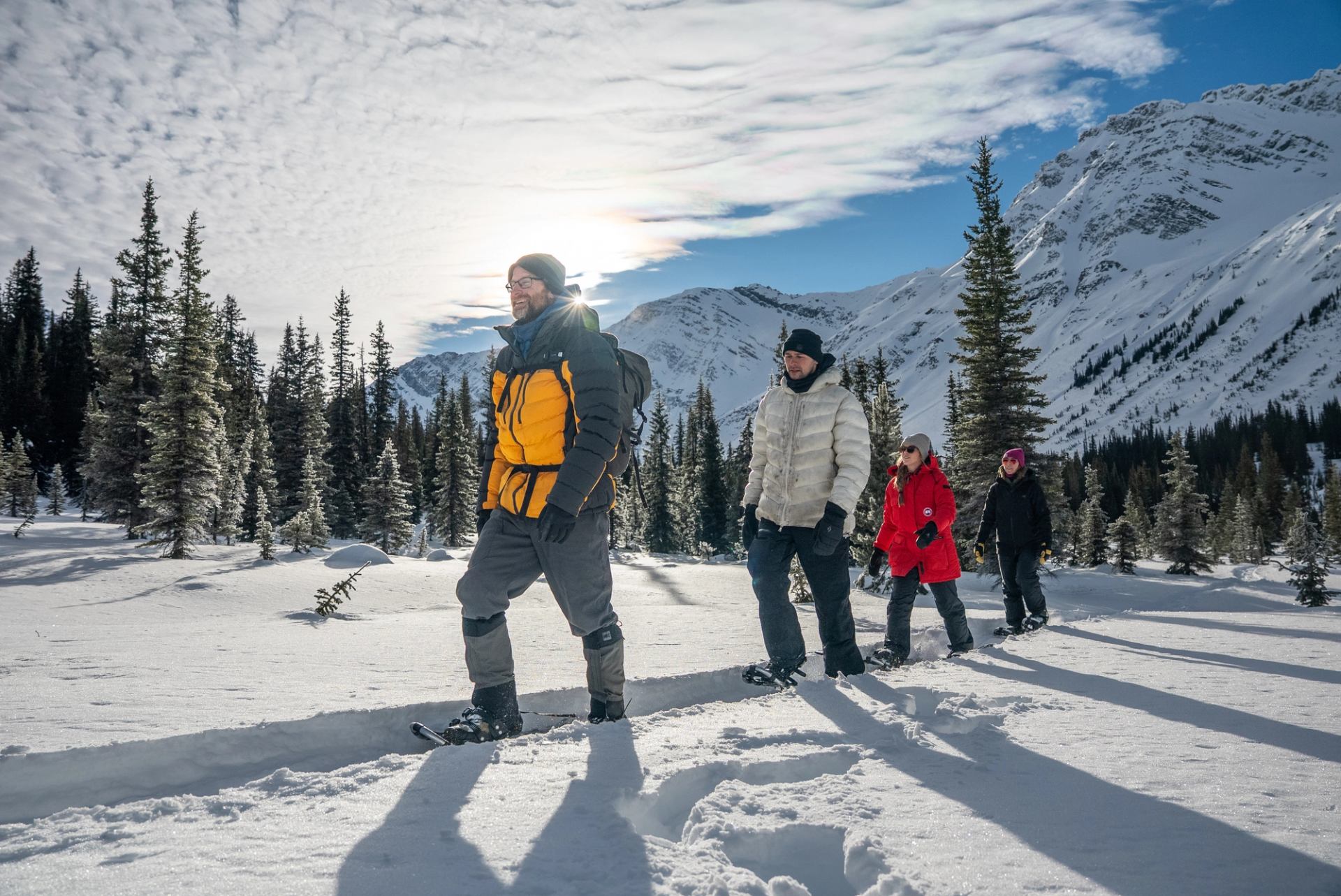 A group snowshoeing on a snowy trail.