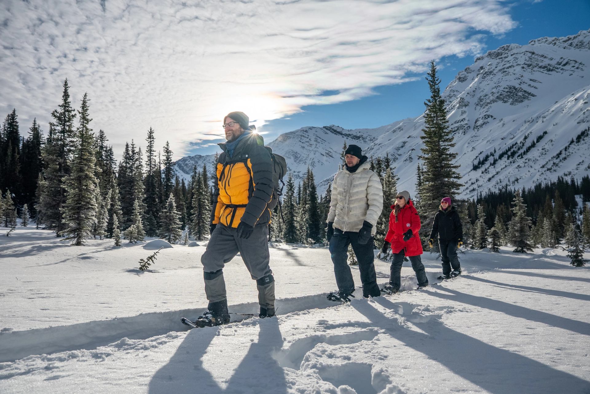 A group snowshoeing on a snowy trail.