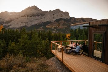 A couple sitting on the deck at Skyridge Glamping in Kananaskis.