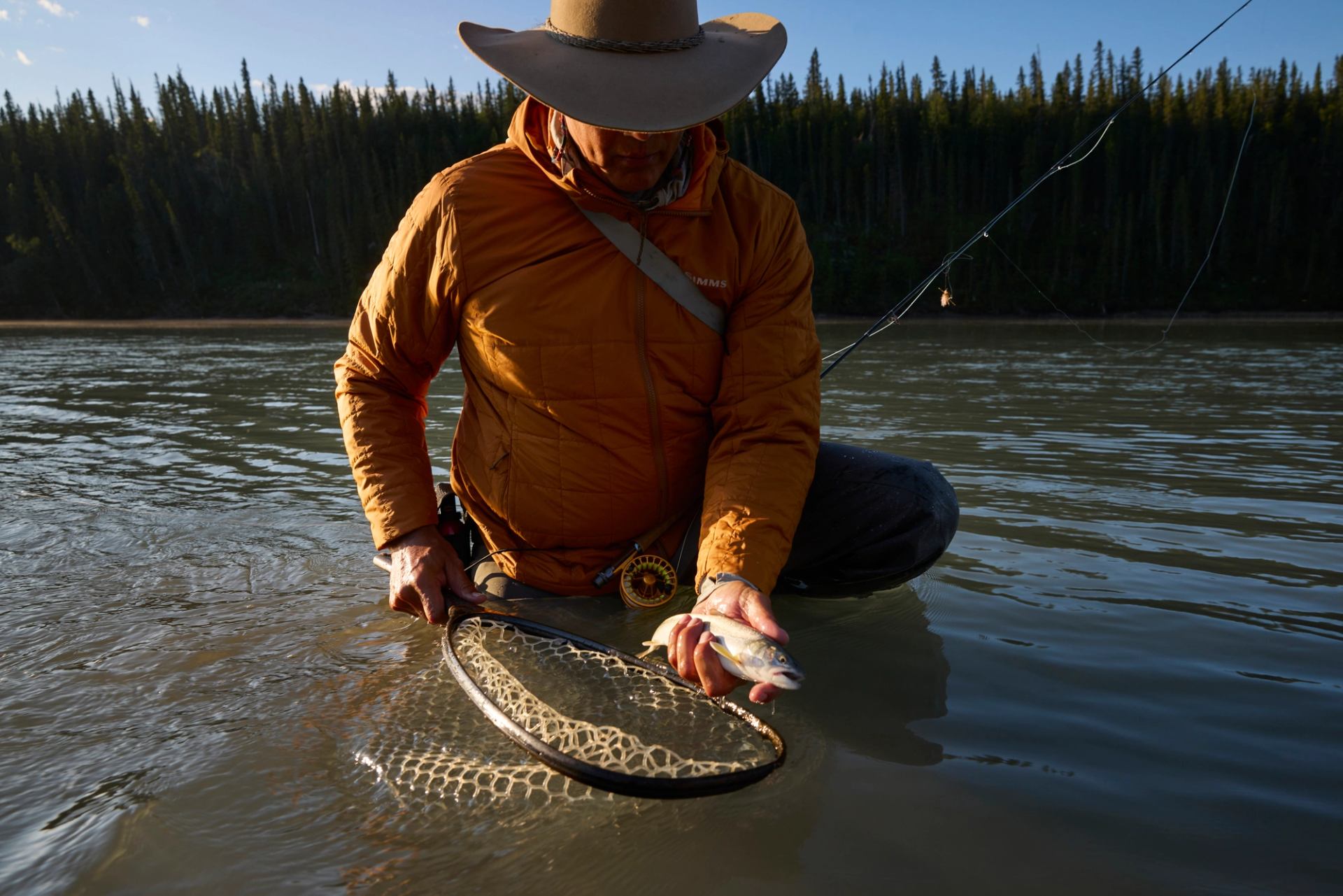 A guide shows the fish caught while fly fishing in the river.