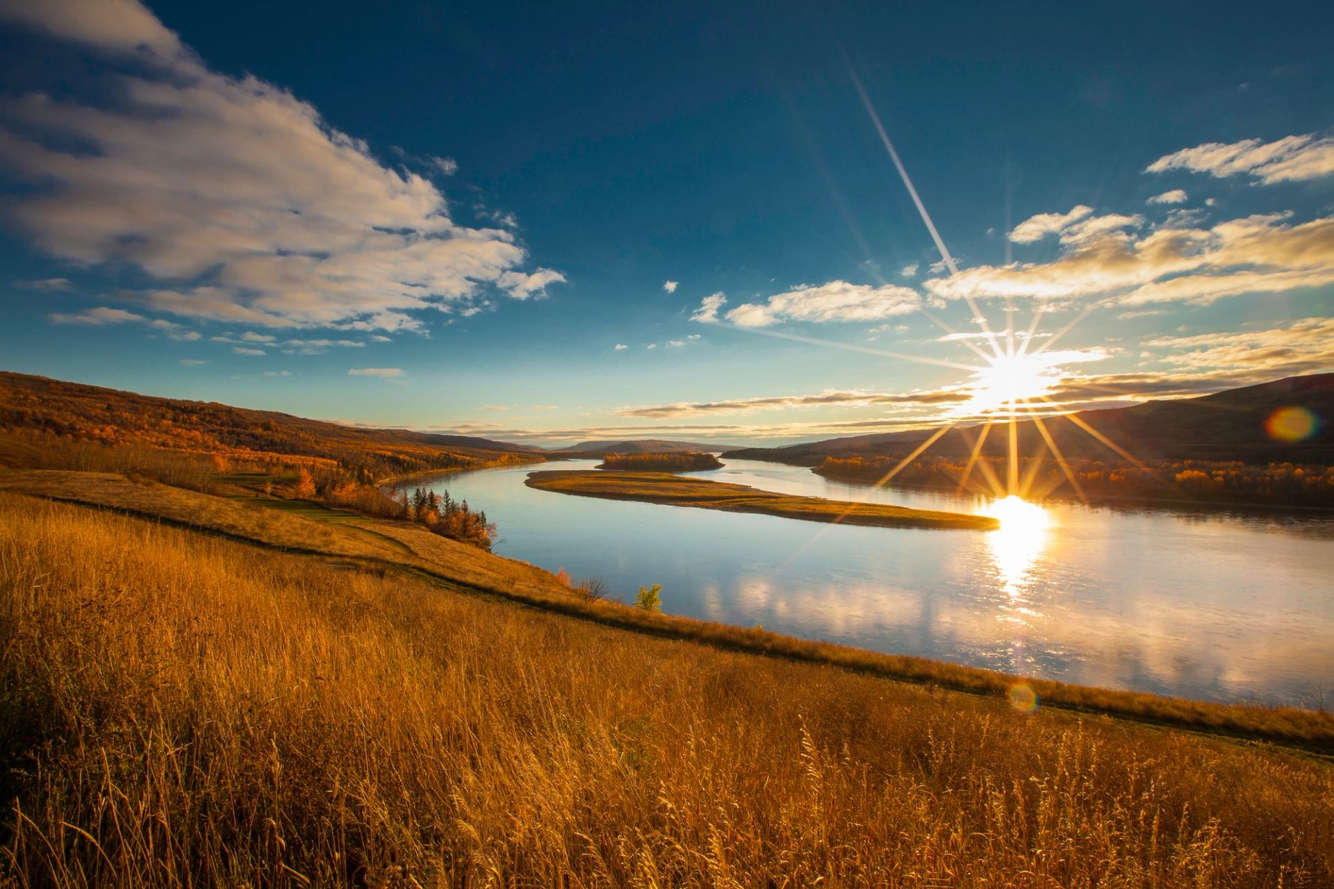 A sunset over a body of water in the Peace River Valley.