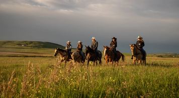 A family ride on horseback in rolling hillside near Millarville.