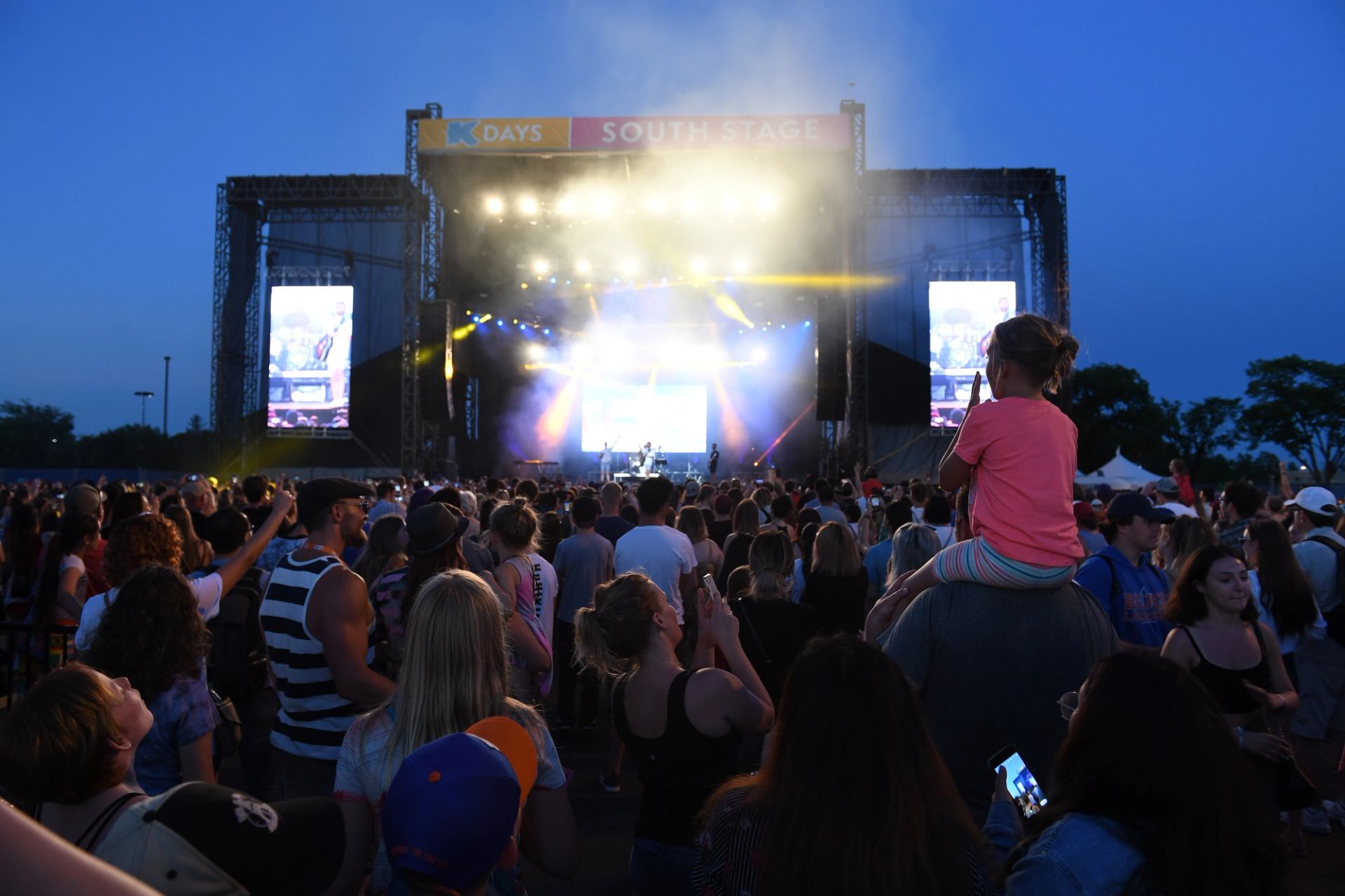 A crowd watches a musicians on stage at night.