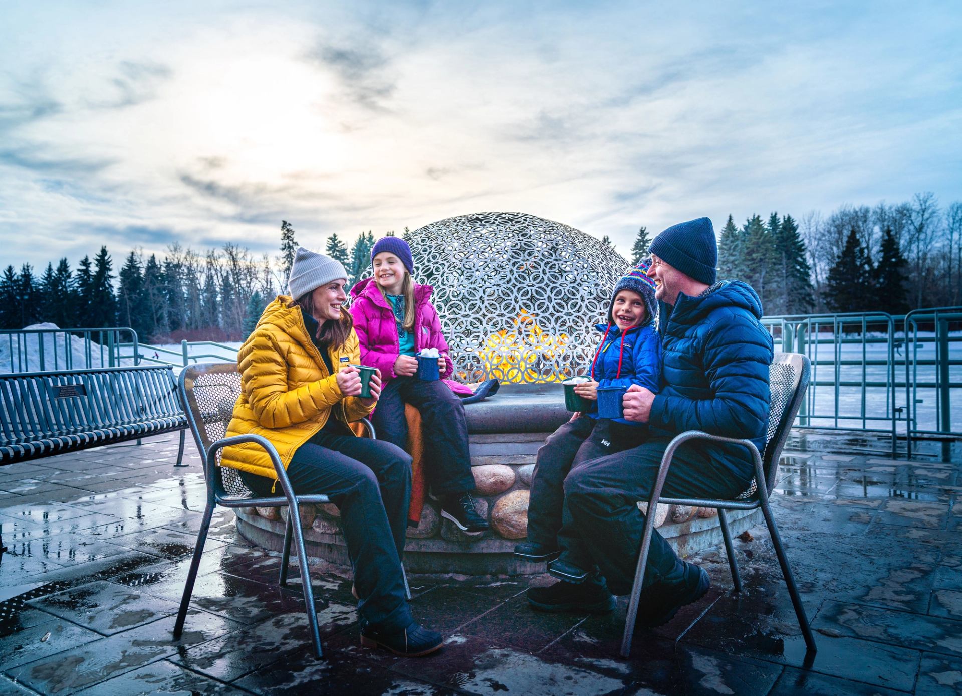 A family sits outside enjoying a hot beverage at Hawrelak Park in Edmonton