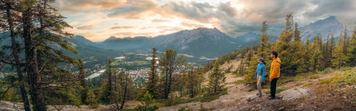 A pano shot of two hikers overlooking the view of Banff from Tunnel Mountian.