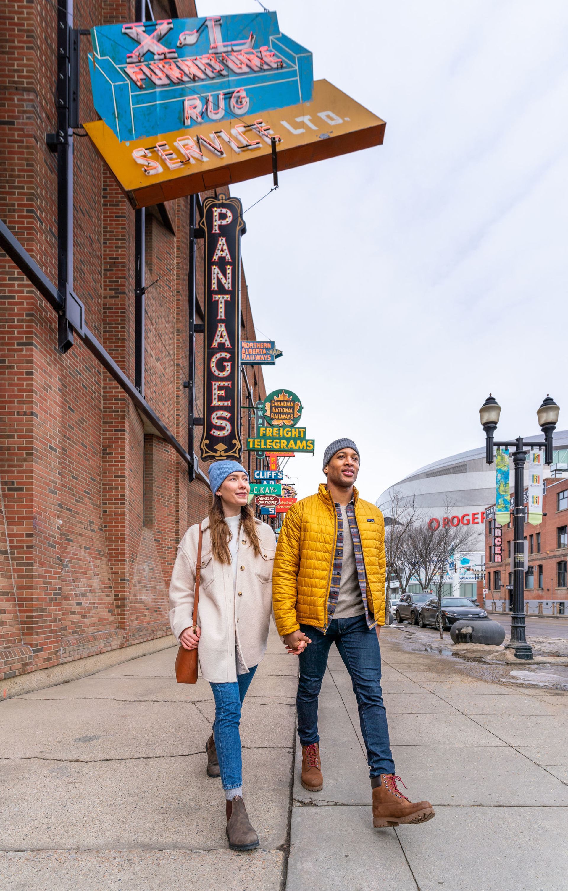 Couple walking hand in hand down the street in downtown Edmonton.