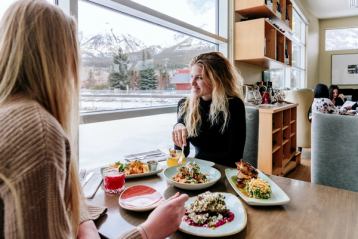 Two ladies enjoying lunch with a mountain view in the background