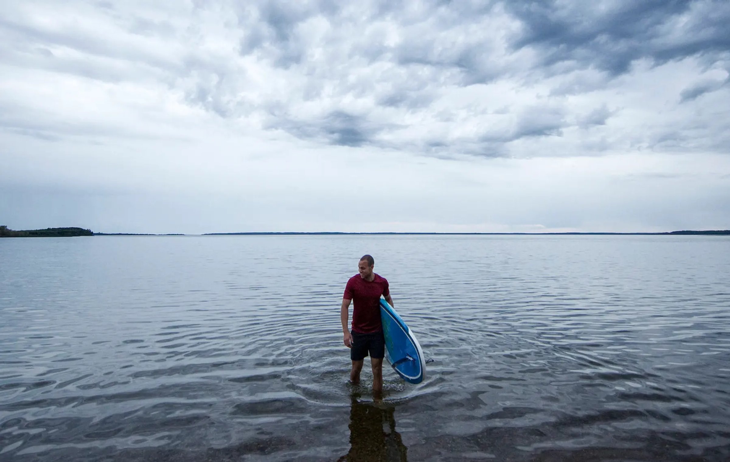 man holding SUP board in Sir Winston Churchill Provincial Park