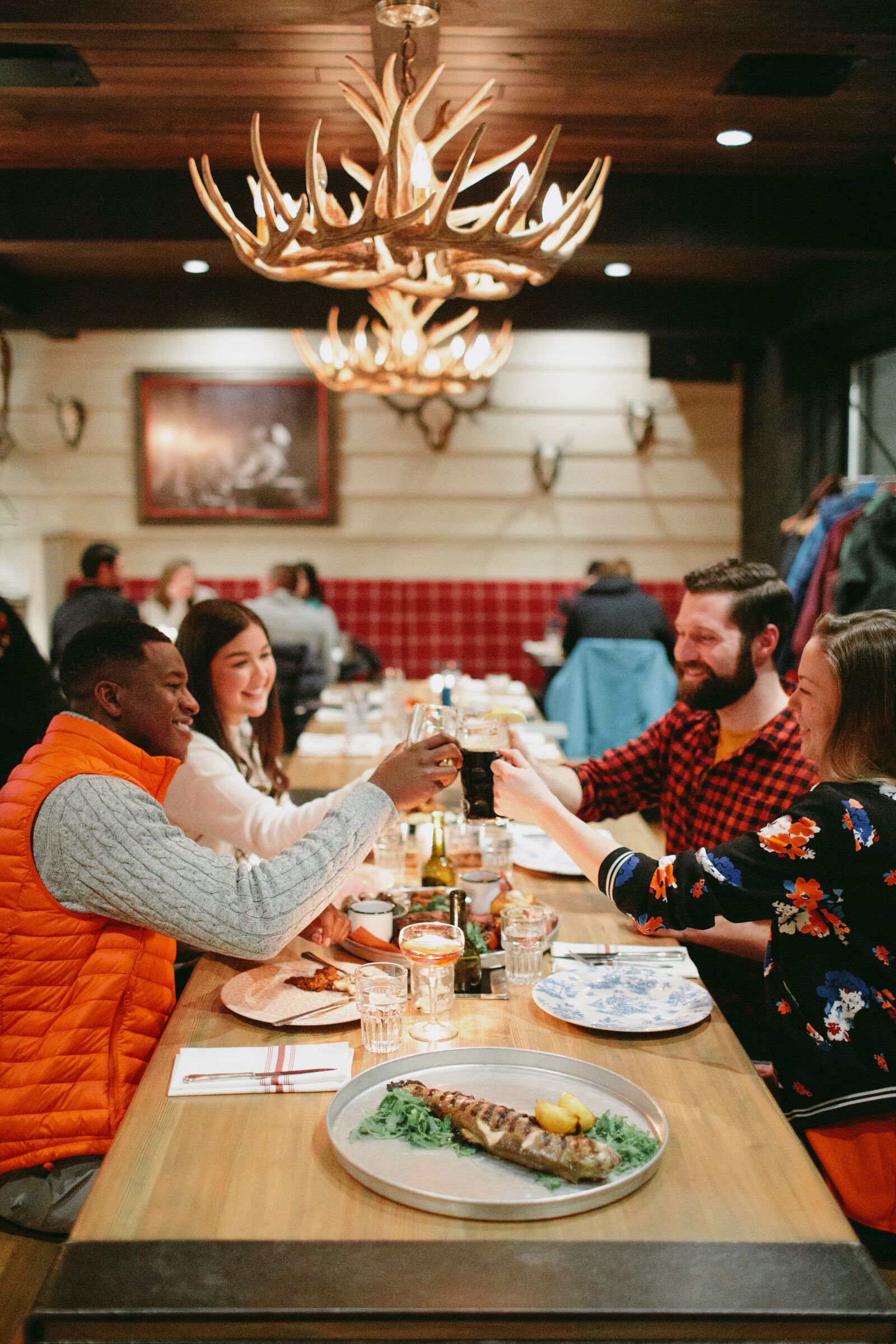 Friends cheersing before eating at Park Distillery in Banff National Park.