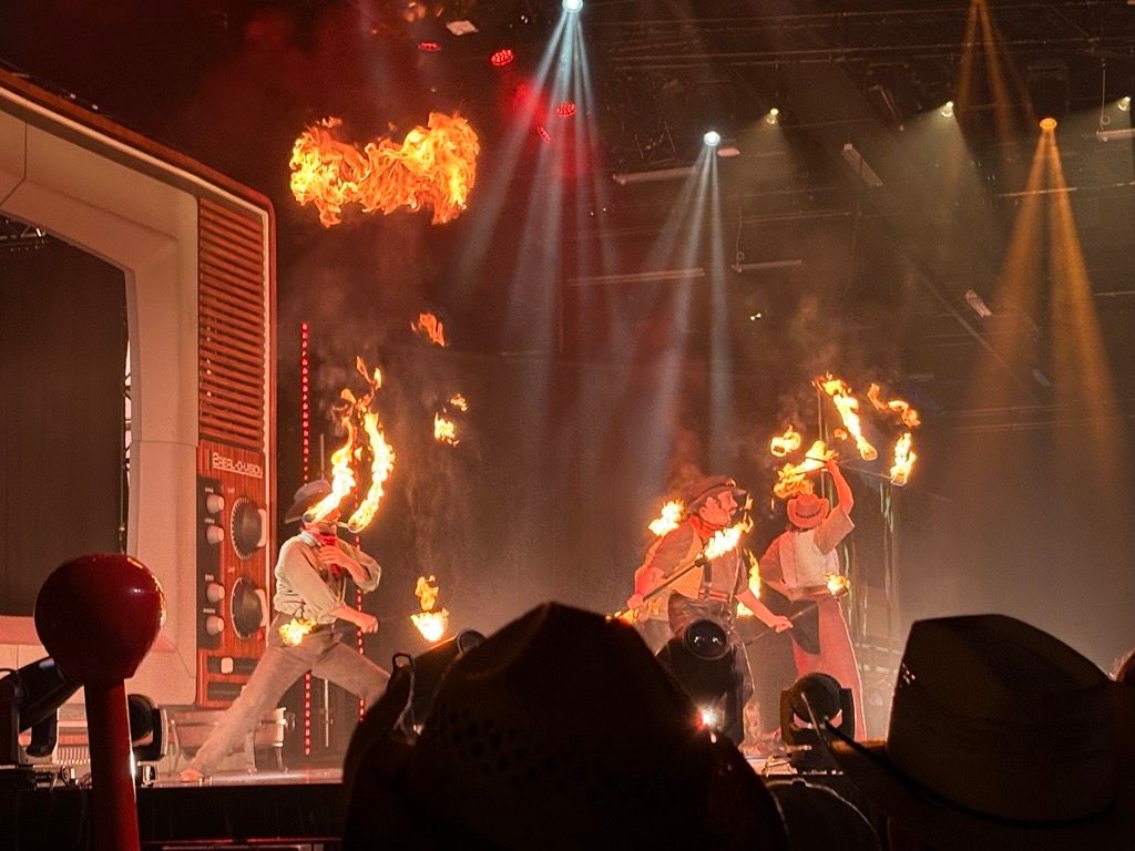 Performers swing batons lit with flames on stage at the Calgary Stampede.