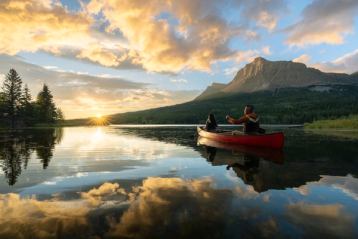 A couple goes out on a canoe at Glamping Resorts in Castle Provincial Park during a fiery sunrise.