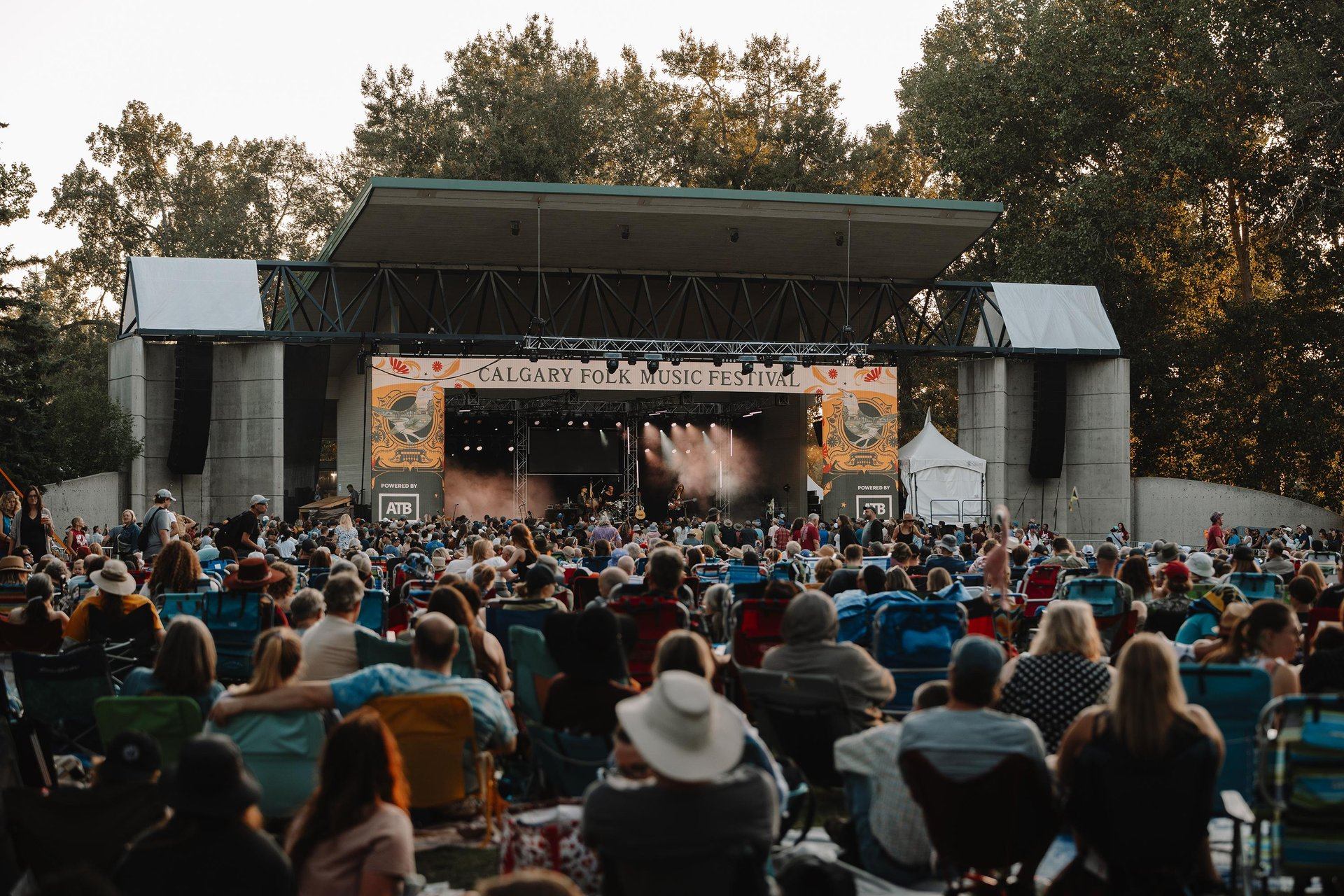 A crowd enjoying a live music performance outside at the Calgary Folk Music Festival.