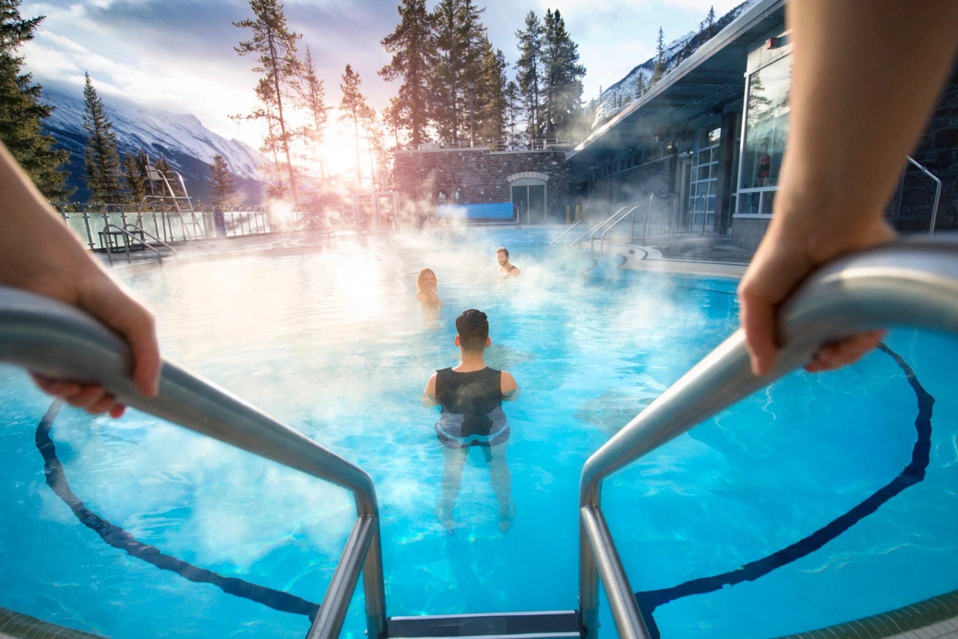 Person getting into the Upper Banff Hot Springs in winter.