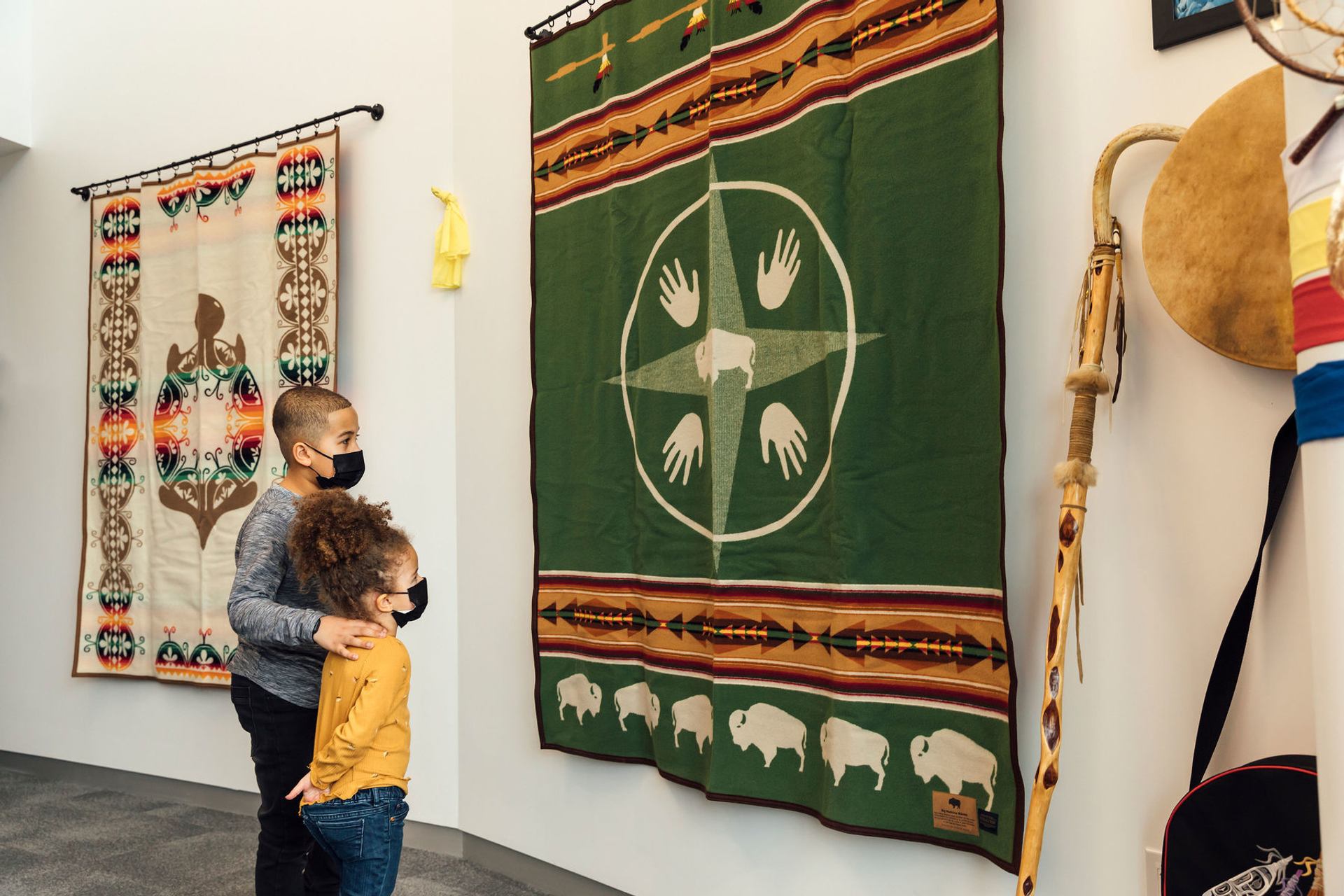 Young visitors look at Indigenous textile in the Indigenous Traditional Room at the TELUS World of Science.