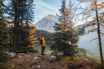 A hiker enjoys a view of a lake.