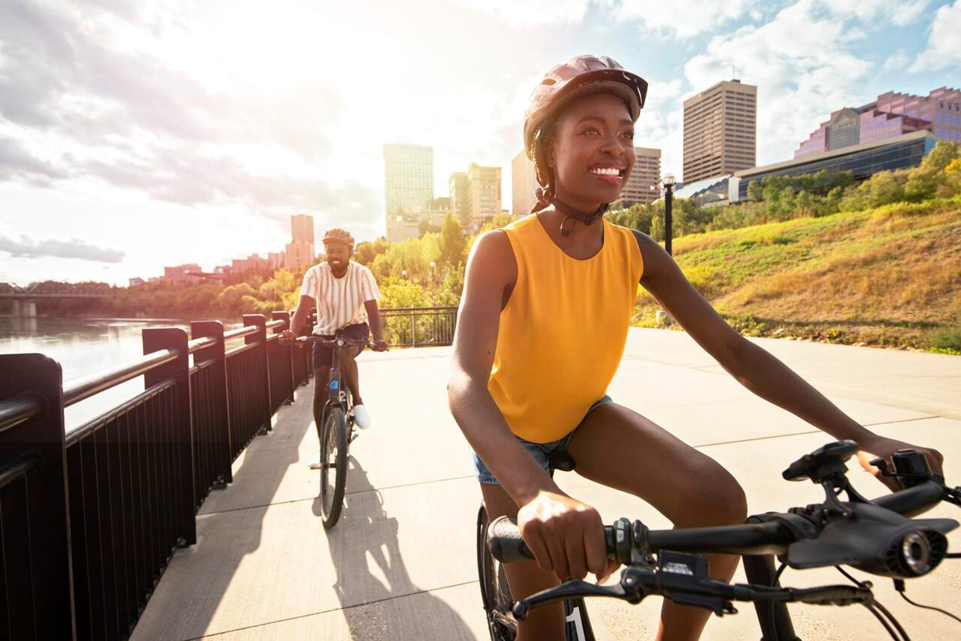 Two people ride along the river pathway in Edmonton