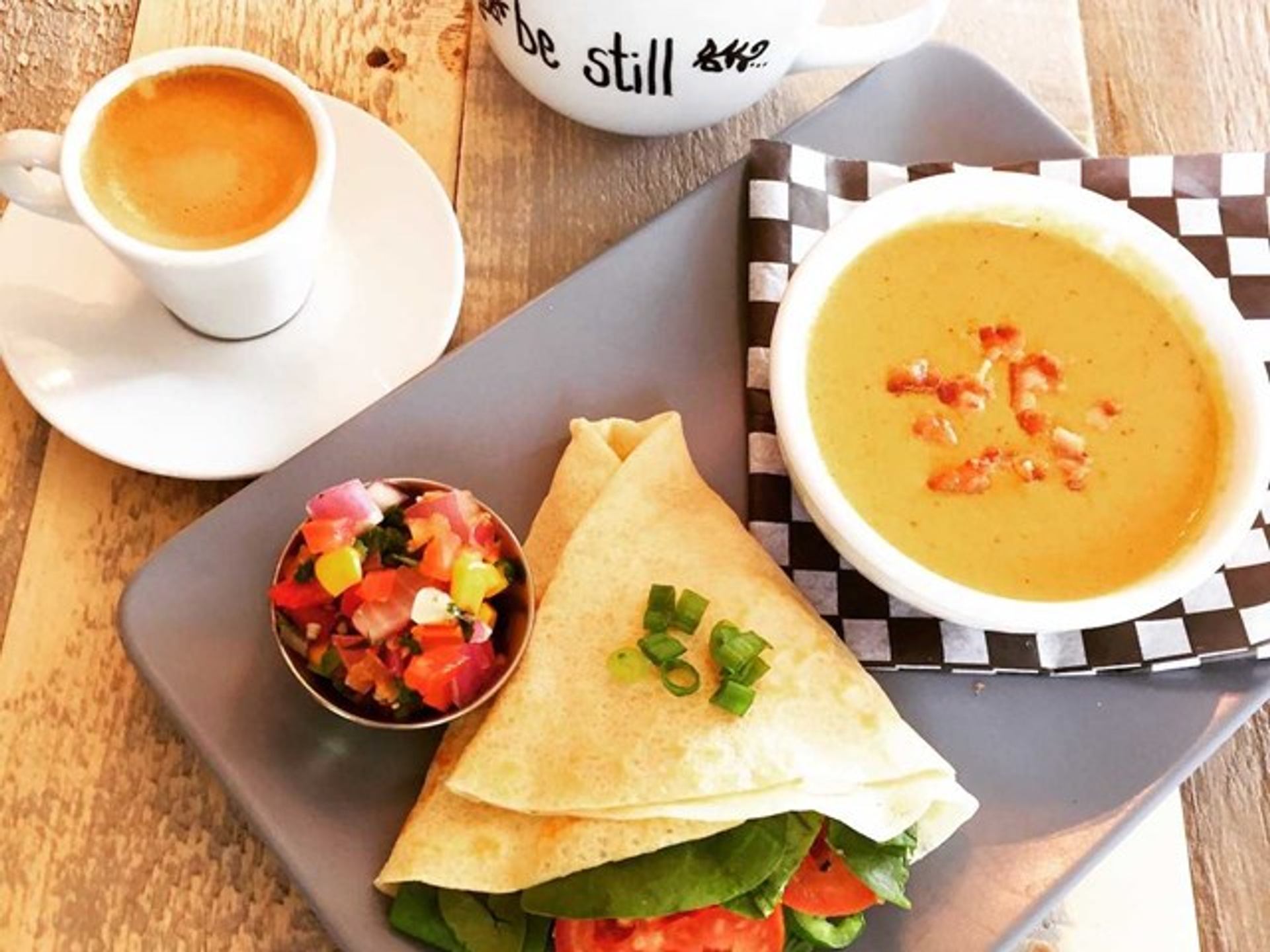 A plate with a single crepe and a bowl of soup