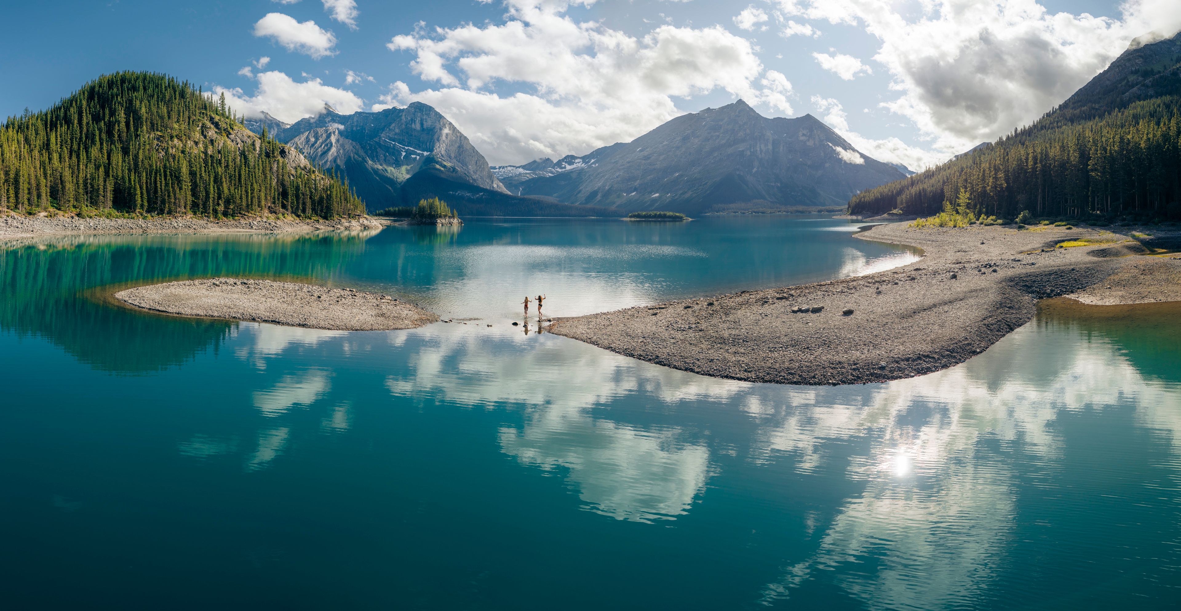 Two swimmers running into Upper Kananaskis Lake