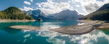 Two swimmers running into Upper Kananaskis Lake