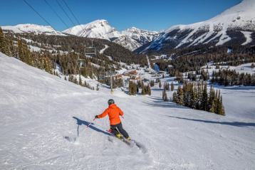 A skier skiing down intermediate runs under the chairlift, at Sunshine Village in Banff National Park