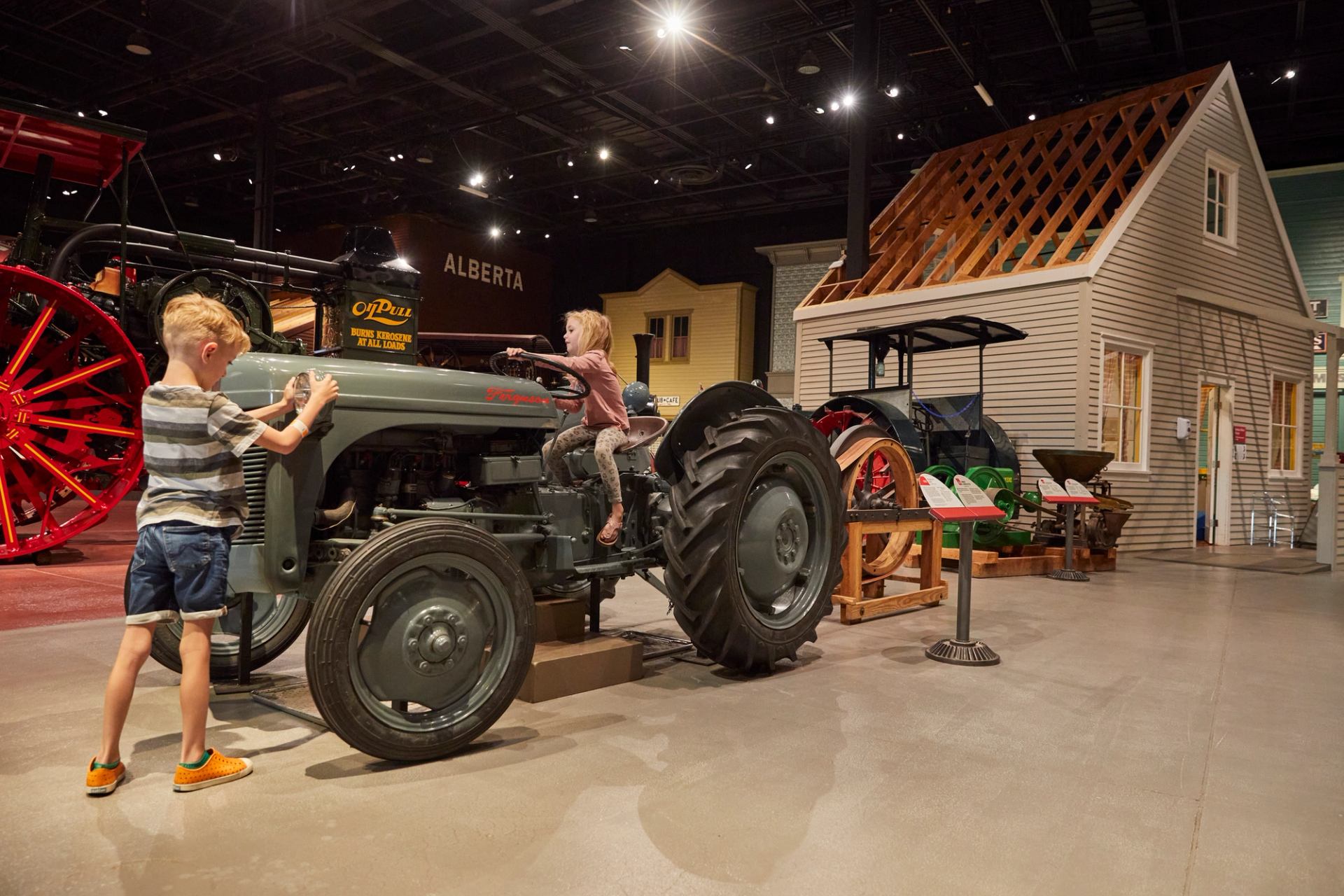 Two children explore a tractor at the Reynolds-Alberta Museum in Wetaskiwin.