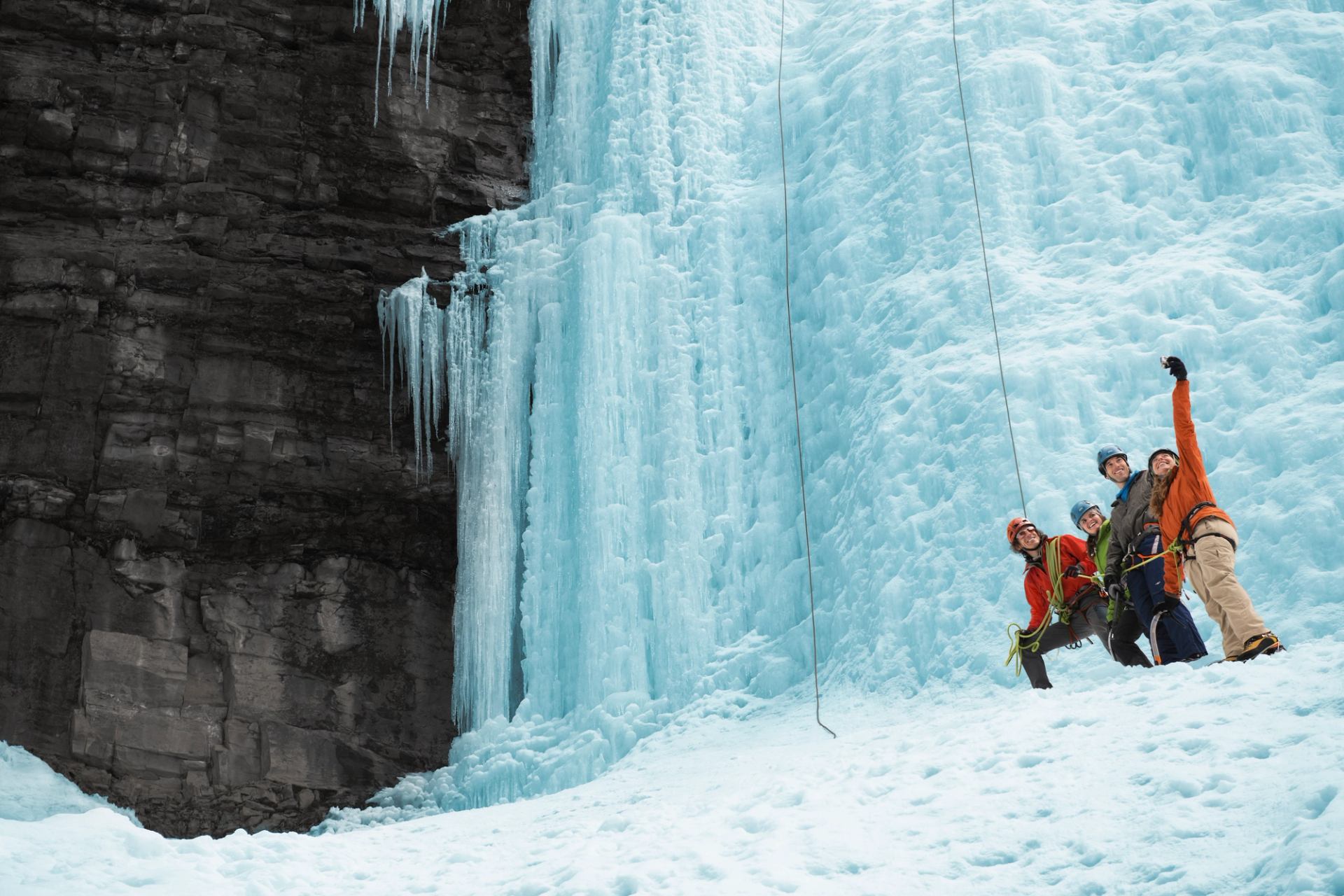 A group of people take a selfie while ice climbing in Johnston Canyon in Banff National Park