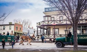 Horse-drawn wagon and people on the street at Christmas time at Heritage Park Historical Village in Calgary