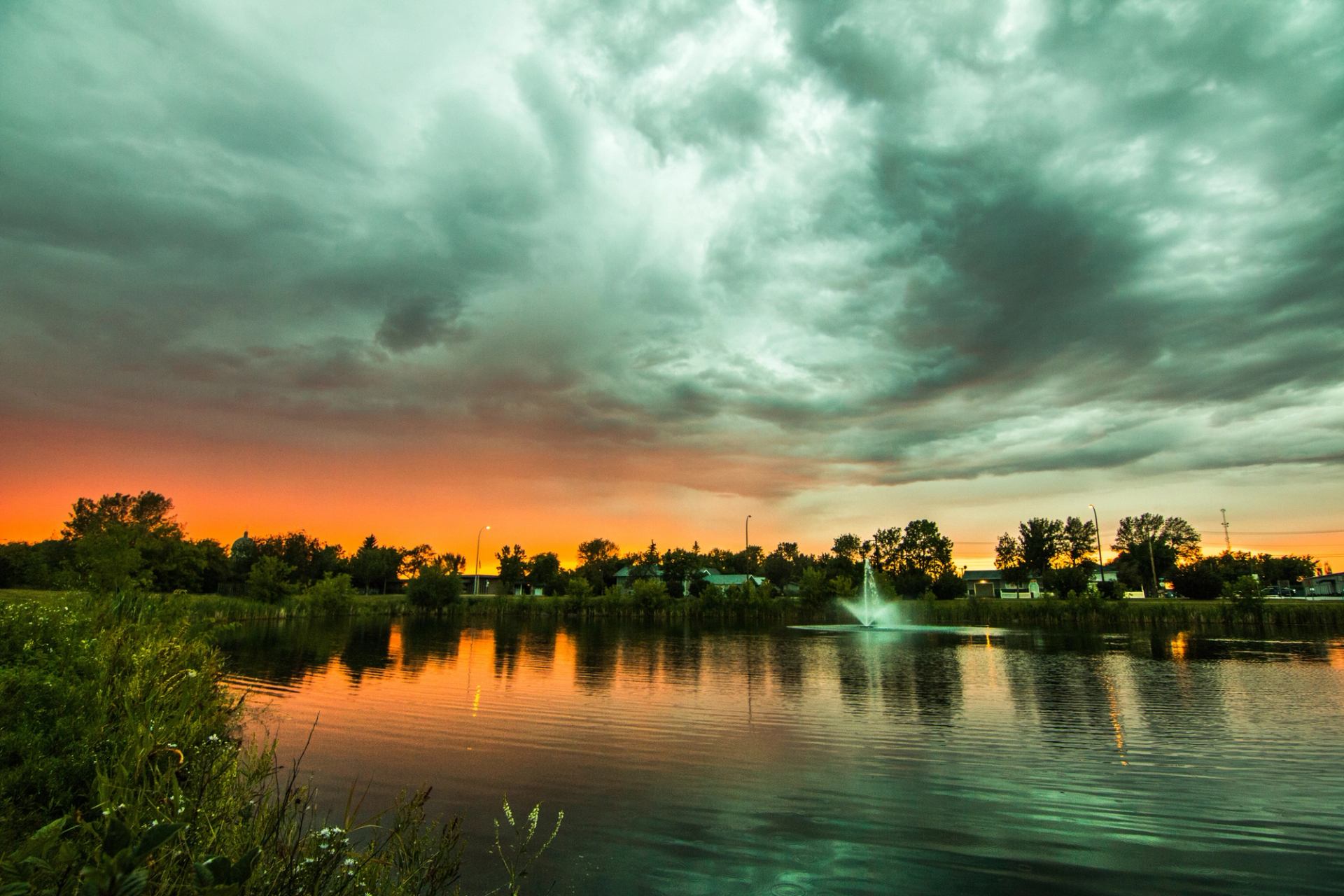 Town of Bonnyville reflecting on calm water at sunset.