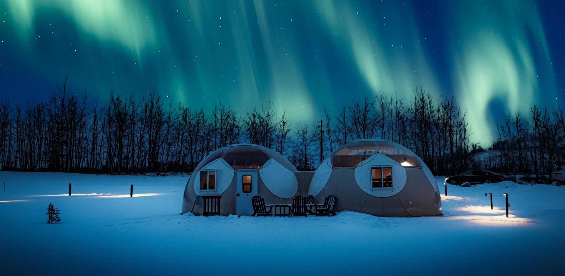 Two domes are lighted up with the auroras above in the night sky