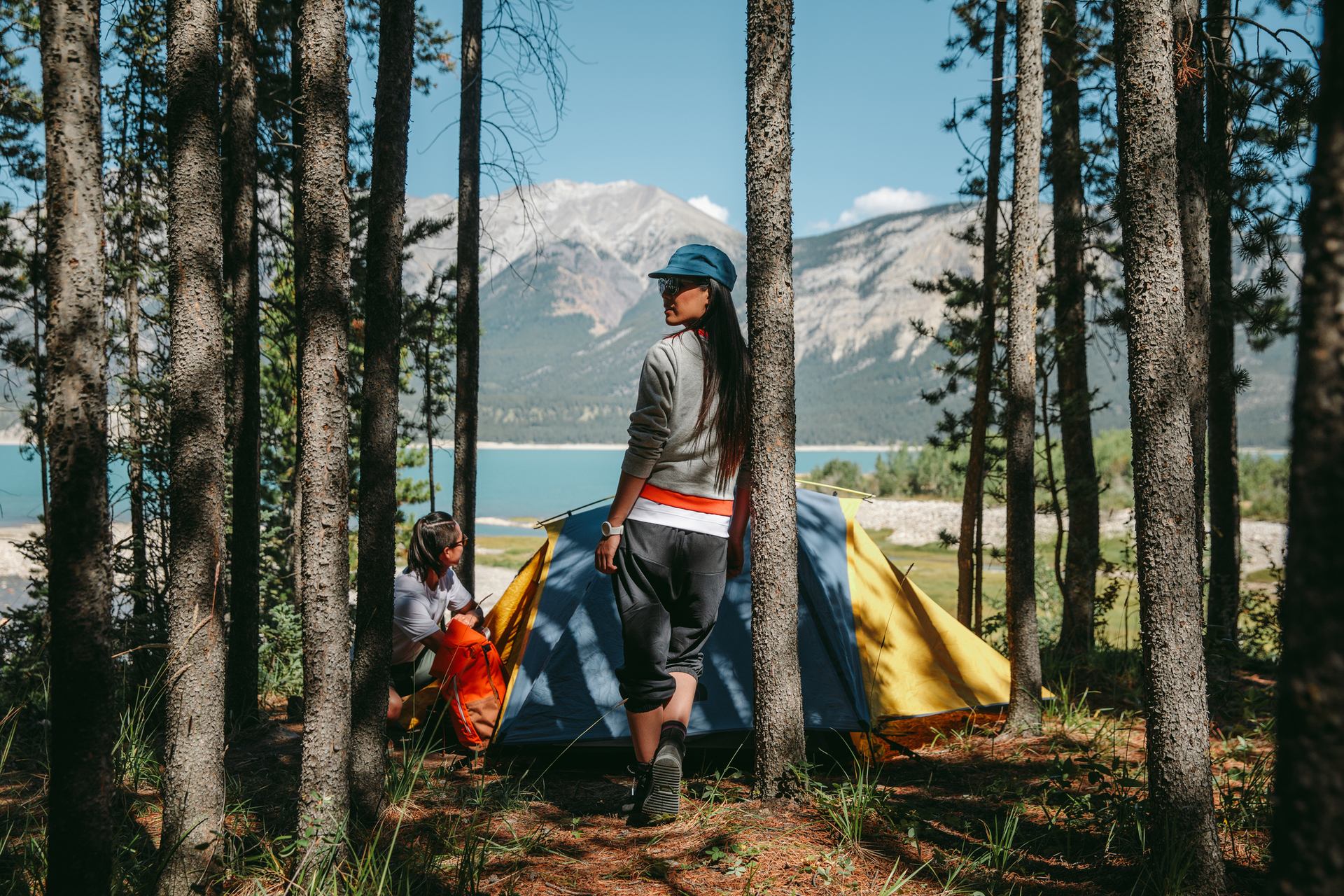 A couple setting up a tent by a lake in the backcountry