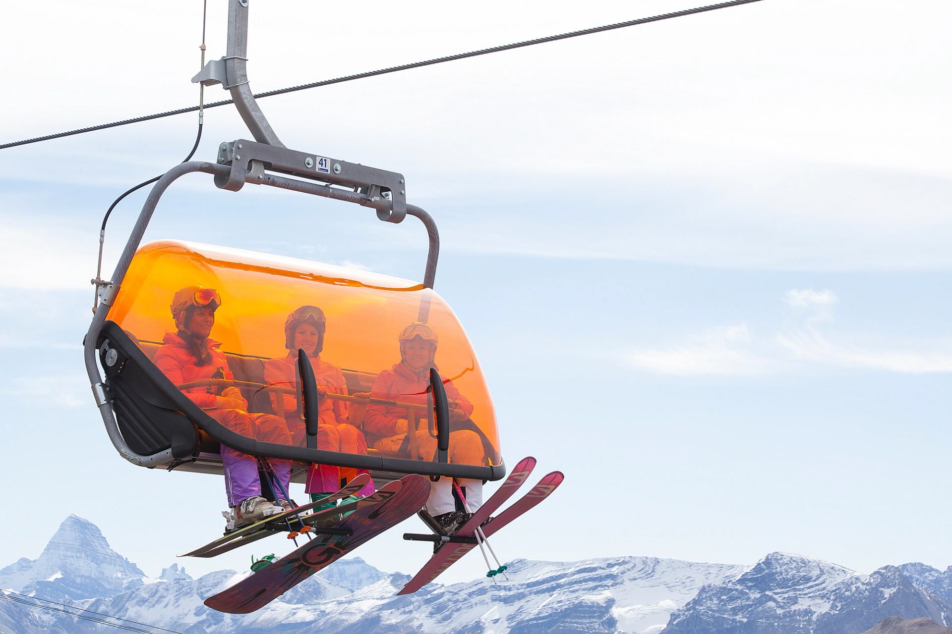 Three skiers ride the heated chairlift at Sunshine Village in Banff National Park.