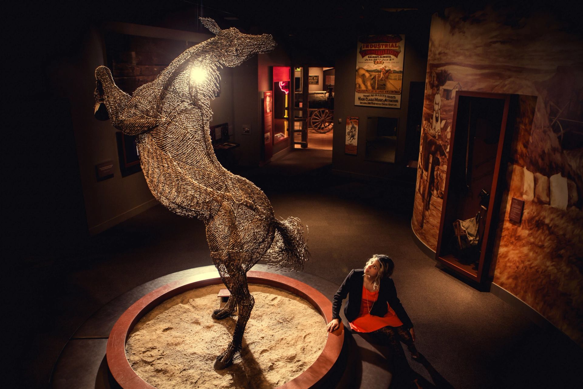 Woman looking at horse sculpture on display inside the Glenbow Museum in Calgary