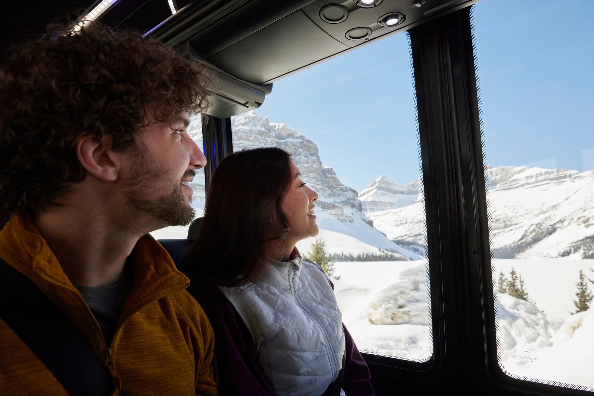 A couple takes in the view outside the Sundog tour bus while driving along the Icefields Parkway.