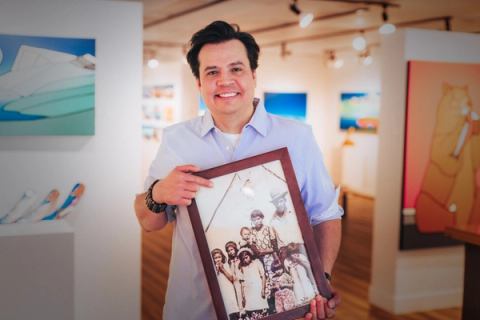 A man holding a framed picture.